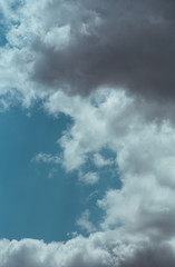 Fluffy clouds cover the summer blue sky