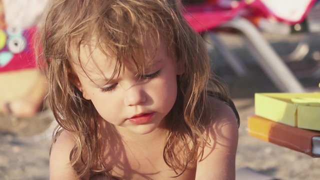 Beautiful little girl playing on a sandy beach