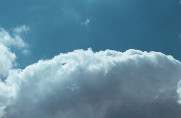 Fluffy clouds cover the summer blue sky