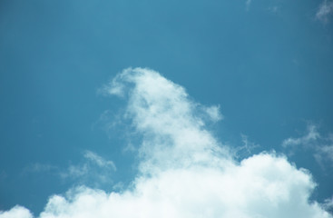 Fluffy clouds cover the summer blue sky