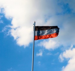 DNR flag on a background of blue sky. A disheveled flag.