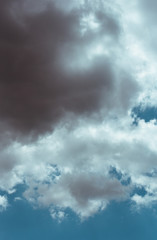 Fluffy clouds cover the summer blue sky