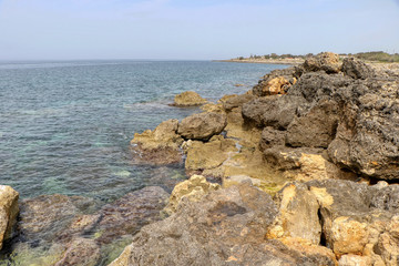 Fototapeta na wymiar Rocks in the sea in full May on the coast of Taranto, Puglia, Italy