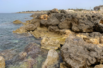 Rocks in the sea in full May on the coast of Taranto, Puglia, Italy