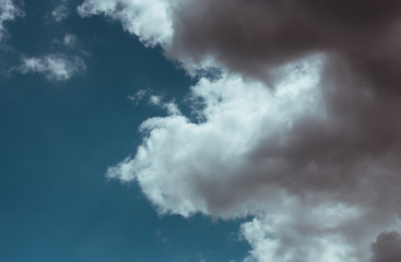 Fluffy clouds cover the summer blue sky