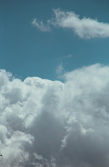 Obraz premium Fluffy clouds cover the summer blue sky