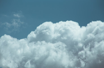 Fluffy clouds cover the summer blue sky