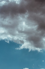 Fluffy clouds cover the summer blue sky