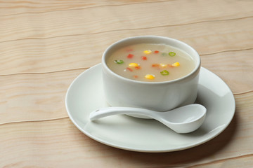Sweet corn soup served in bowl on wooden background. Hot Soup. 
