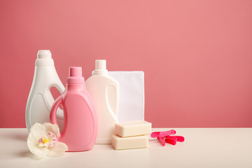 Detergents, washing powder, soap and orchid flower on pink background