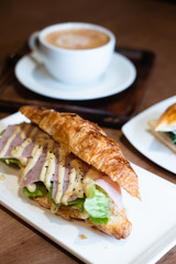 Ham croissant sandwich and coffee