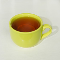 black tea with lime in a green glass cup.