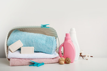 Laundry basket with towels, soap, detergents on white background