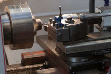 Industrial practice of students on a lathe machine in a factory.