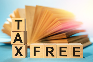 Wooden cubes with the abbreviation TAX FREE on the background of an open book.