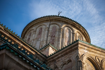 A crucifix on the roof of the monastery of Ghelati illuminated by the sun.