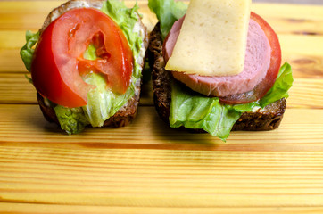 fresh sandwich with sausage and lettuce on the table