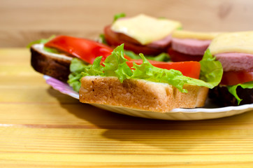 fresh sandwiches with vegetables, meat and cheese close-up