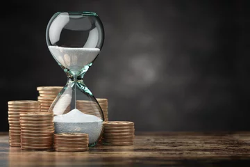 Fotobehang Golden coins and hourglass clock. Return on investment, deposit, growth of income and savings, time is money concept. © Maksym Yemelyanov