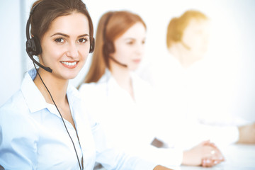 Call center operators. Focus on beautiful business woman using headset
