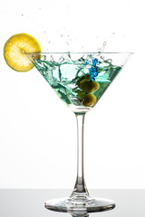 cocktail with martini, olives and lime wedge
