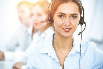 Call center. Focus on beautiful business woman in headset