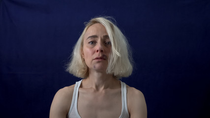 The bruised blonde looks directly at the camera. Violence against women. Sexual harassment.