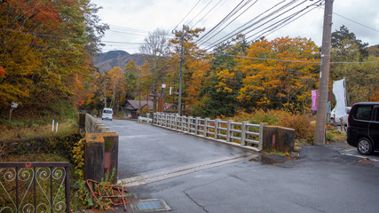 Beautiful scene of small bridge over the river with colorful autumn trees for background with copy space , Nikko