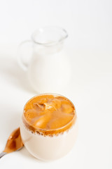 Korean Coffee Dalgona. Iced fluffy creamy whipped trend coffee drink with coffee foam and milk. Covid-19 city lockdown and self-quarantine trendy IT-drink drink, stay at home concept.
