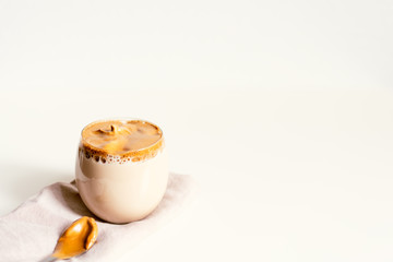 Korean Coffee Dalgona. Iced fluffy creamy whipped trend coffee drink with coffee foam and milk. Covid-19 city lockdown and self-quarantine trendy IT-drink drink, stay at home concept.
