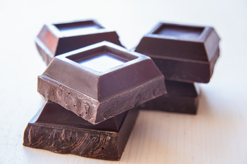 Pieces of dark chocolate on wooden surface