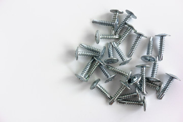 Silver-colored metal self-tapping bolts on white isolate