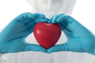 Thank you coronavirus helpers concept. Hand of doctor in heart shape isolated on hospital blur background for love and care in medical healthcare.