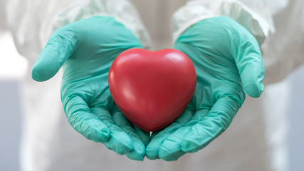 Thank you coronavirus helpers concept. Hand of doctor in heart shape isolated on hospital blur...