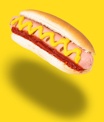 Hot dog with mustard isolated on yellow.