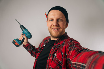 builder is a man of Caucasian portrait as taking selfie on smartphone.