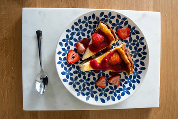 Cheesecake with fresh strawberries and strawberry sauce on a colorful plate. Delicious dessert.