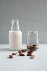 Almond milk in the glass bottle with almonds. Healthy vegetarian food and drink concept.