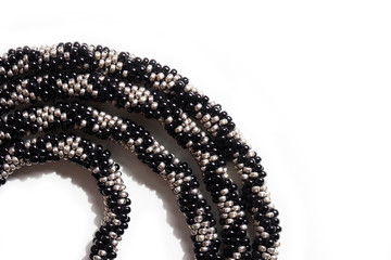 Beadwork, black and silver bead beads on a white background