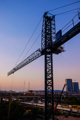 Fototapeta na wymiar Industrial construction cranes and building silhouettes twilight