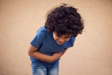 Kid boy feels stomach ache. Children, healthcare and medicine concept