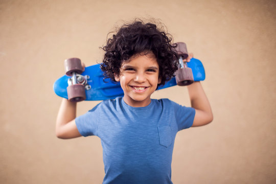 A portrait of happy kid boy holding skateboard. Children,leisure and lifestyle concept