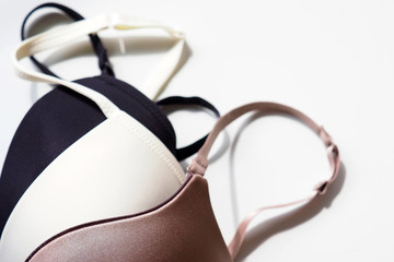 Stack of sexy bras on white background, bra. Push up lingerie, classic colors: white, black, beige