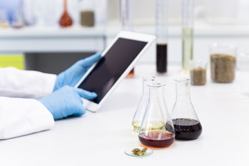 Scientist’s hands working with tablet in cbd laboratory