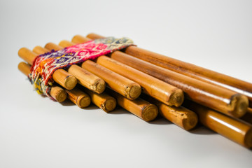 The pan flute is a handcrafted musical instrument made up of reeds of different sizes joined by a colored ribbon