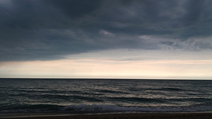 Fototapeta na wymiar Dark clouds and light over sea