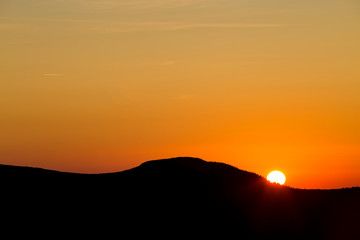 Sunrise in the clear cloudless sky on the mountain. Summer sunrise in the mountains