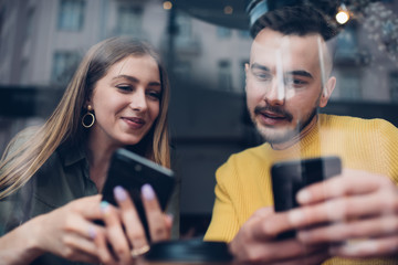 Friends using phones in cafe