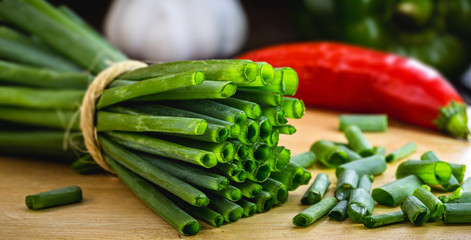 Culinary ingredient, known as Allium schoenoprasum, chives, leeks, chives. Sliced ​​on rustic kitchen board