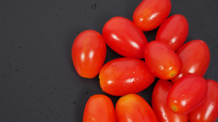 Close up group of Cherry Tomatoes on black background.